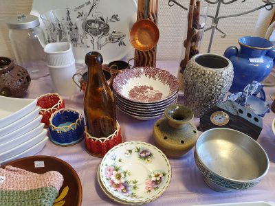Ett loppisbord fyllt av porslin, vaser, och inredningsprylar.