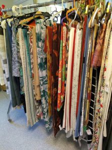 En klädställning med tyger och gardiner i blandade färger och mönster.